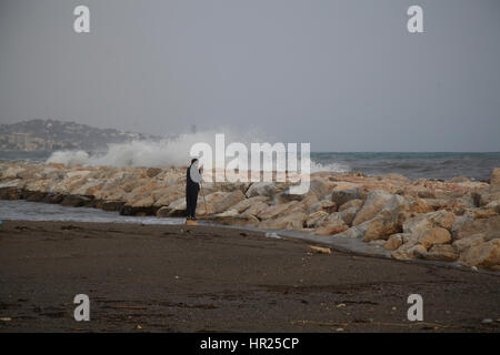 Ein Junge auf der Suche trifft eine große Welle einen Wellenbrecher. Malaga. Spanien Stockfoto