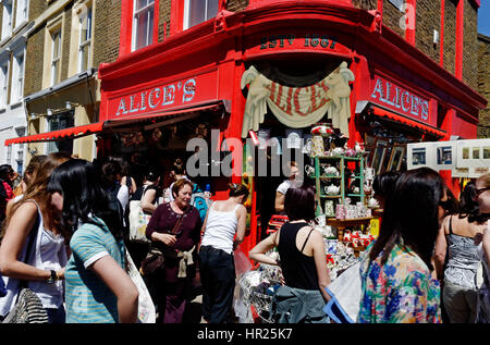 Menschen auf der Suche an Ständen auf der belebten Portobello Road Antiquitätenmarkt in London Stockfoto