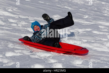 Ein kleiner Junge (4 Jahre alt) in die Luft sprang auf einem Schlitten in Quebec winter Stockfoto