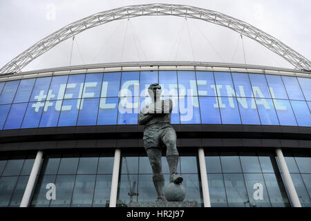 Einen Überblick über die Sir Bobby Moore-Statue vor dem Boden und "EFL Pokalfinale" auf der großen Leinwand draußen vor der EFL-Cup-Finale im Wembley Stadium, London. Stockfoto