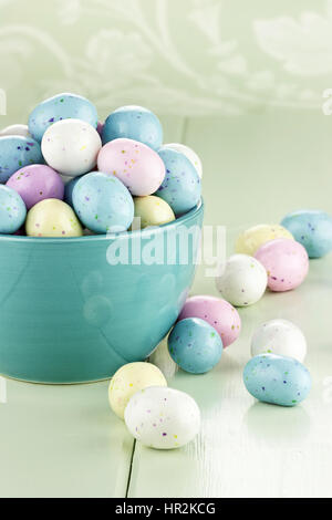 Eine blaue Schale gefüllt mit gesprenkelten Ostereier Süßigkeiten. Geringe Schärfentiefe. Stockfoto