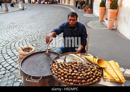 Mann, Verkauf von gerösteten Kastanien an einer Straßenecke am Piazza Navona, Rom, Italien Stockfoto
