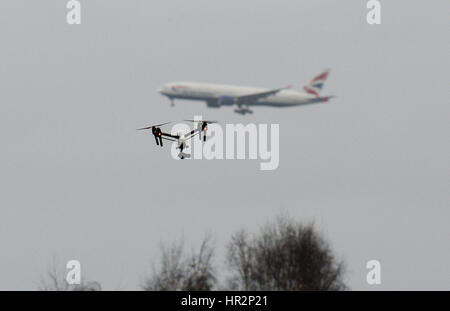 Eine Drohne fliegt im Hanworth Park in West London, als British Airways 747 Flugzeug zu landen am Flughafen Heathrow hinter bereitet. Stockfoto