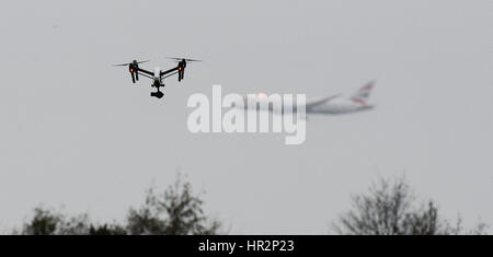 Eine Drohne fliegt im Hanworth Park in West London, als British Airways 747 Flugzeug zu landen am Flughafen Heathrow hinter bereitet. Stockfoto