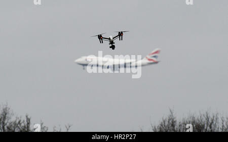 Eine Drohne fliegt im Hanworth Park in West London, als British Airways 747 Flugzeug zu landen am Flughafen Heathrow hinter bereitet. Stockfoto