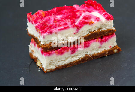 Vegane rohe Himbeeren Käsekuchen auf einem dunklen Hintergrund. Liebe für eine gesunde vegane Ernährung Konzept Stockfoto