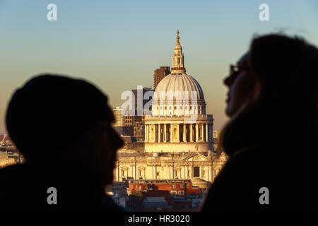 St. Pauls Cathedral durch zwischen zwei unbekannten Touristen gesehen Stockfoto