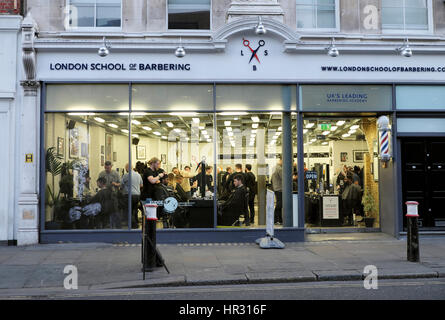 Außenansicht Innenraum London Schule der Barbering Shop mit Auszubildenden Haare schneiden von Klienten in Smithfield, London KATHY DEWITT Stockfoto