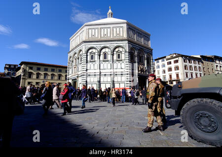 Florenz, Italien - 25. Februar 2016: Baptisterium (Battistero di San Giovanni, Baptisterium des Heiligen Johannes) auf die Piazza del Duomo mit bewaffneten Soldaten für th Stockfoto