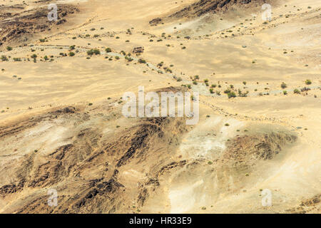 Luftaufnahme von einem Flug über Kaokoveld in Namibia.  Die wechselnden Farben der Wüste unten mit ausgetrockneten alten Wasserwege. Stockfoto