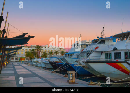 Boote für den Abend im Hafen von Marina unter dramatischen Sonnenuntergang Farbe Magenta.  Ende von einem warmen, sonnigen Tag in St. Antoni de Portmany, Ibiza, Spanien. Stockfoto