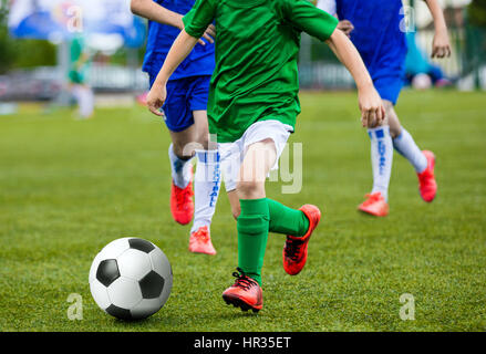 Jungen Kids Kinder spielen Fußball-Fußball-Spiel. Fußball-Spieler im grünen und blauen Uniformen laufen. Jungs treten Fußball Stockfoto