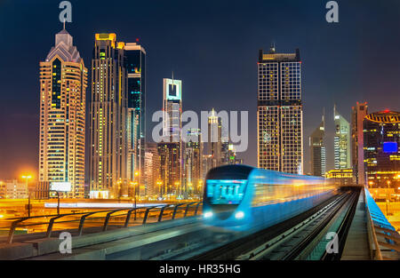 Selbstfahrender u-Bahn-Zug mit Wolkenkratzern im Hintergrund - Dubai, Vereinigte Arabische Emirate Stockfoto