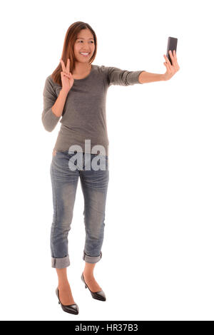 Voller Körper einer lässigen glücklich lächelnde Frau stehen und machen Selfie Foto per Smartphone auf weißem Hintergrund. Stockfoto