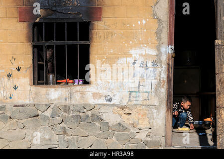 YuanYang, China - 20. Februar 2017: Hani House, eines der 56 Minoritäten in China mit einem jungen Kind spielen in. Stockfoto