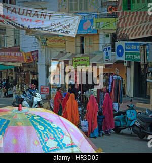 Frauen in typisch bunten Rajasthani-Kleid im Gespräch auf dem belebten Markt von Udaipur, Indien Stockfoto