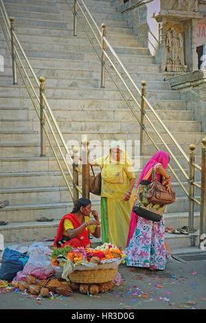 Unbekannte Frau verkaufen Blüten und Girlanden, Gläubige auf den Stufen des Jagdish Hindu-Tempel im Zentrum von Udaipur, Indien Stockfoto