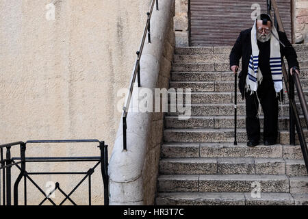 Jerusalem, Israel. 27. Februar 2017. Einen älteren jüdischen Mann steigt Treppen in das alte jüdische Viertel der Stadt anziehen Talit, Gebetsschal und Tefilin, Gebetsriemen, in den frühen Morgenstunden am ersten Tag des hebräischen Monats von Adar. Bildnachweis: Nir Alon/Alamy Live-Nachrichten Stockfoto