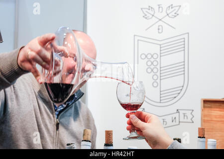 Belgrad, Serbien - 25. Februar 2017: Rotwein in ein Glas für eine Weinprobe während der 2017 Belgrad Tourismus messe Bild eines roten Wi geschüttet wurde Stockfoto