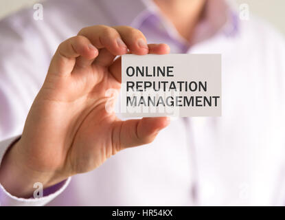 Closeup auf Geschäftsmann hält eine Karte mit Nachricht ONLINE REPUTATION MANAGEMENT, Business Konzept Bild mit soft-Fokus-Hintergrund und Vintage-Ton Stockfoto