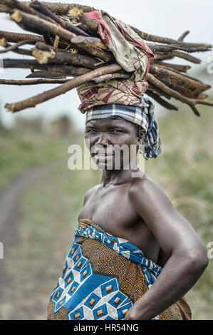 Porträt einer Frau vom Stamm Holi eine Last auf dem Kopf tragen. In Afrika sind viele Dinge noch auf den Köpfen getragen, da nicht jeder hat ein TÜV Stockfoto