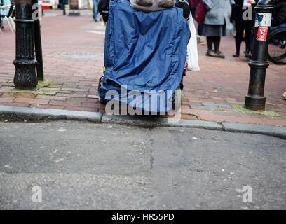 Rollstuhlfahrer haben Probleme mit der Straße und Gehweg Unebenheiten in Brighton UK Stockfoto