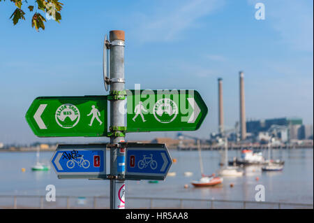 Zeichen für die National cycle Route und die weald Weise an der Promenade Gravesend mit den alten Tilbury Power Station im Hintergrund (abgerissen 2019) Stockfoto