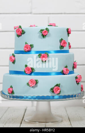 Blaue dreischichtige Kuchen mit rosa Rosen Stockfoto