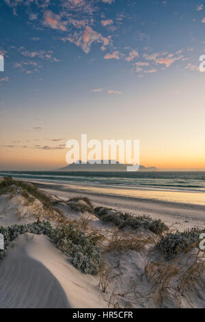 Blick auf den Tafelberg bei Sonnenuntergang von Big Bay Bloubergstrand, Kapstadt, Südafrika Stockfoto