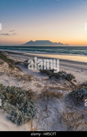Blick auf den Tafelberg bei Sonnenuntergang von Big Bay Bloubergstrand, Kapstadt, Südafrika Stockfoto
