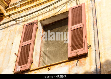 Detail der braunen, offenen Fensterläden an einem Gebäude in der Hauptstraße von La Maddalena - Insel La Maddalena, Sardinien, Italien. Stockfoto