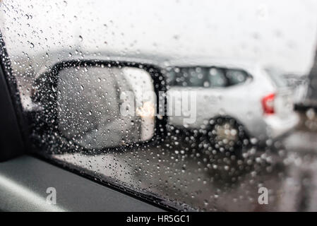 Regentropfen auf den Auto-Rückspiegel. Schwere Regen draußen Stockfoto