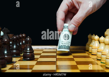 Mann spielt Schach mit hundert Dollar Bill und macht bewegen Stockfoto