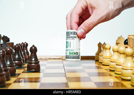 Mann spielt Schach mit hundert Dollar Bill und macht bewegen Stockfoto