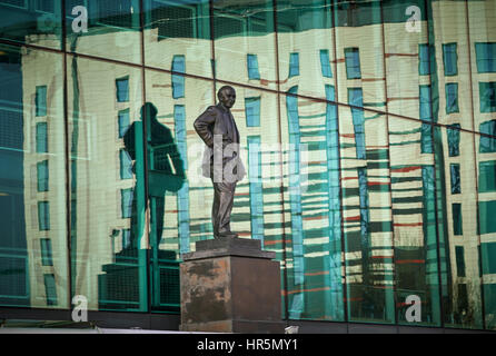 Hotel Fußball spiegelt sich in dem Glas Sir Matt Busby-Statue am Old Trafford Stadion Manchester England, UK Stockfoto