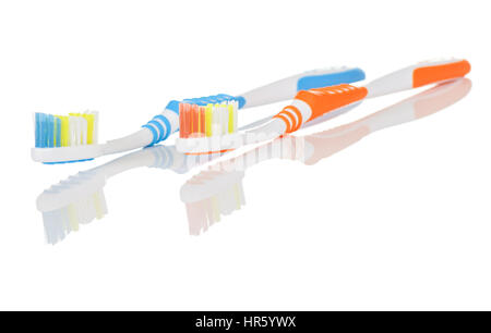 Paar von orangenen und blauen Zahnbürsten auf weißem Hintergrund mit Reflexion Stockfoto