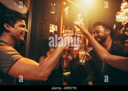 Jugendliche feiern und Toasten Getränke im Nachtclub. Freunde, die gute Zeit im Club. Stockfoto