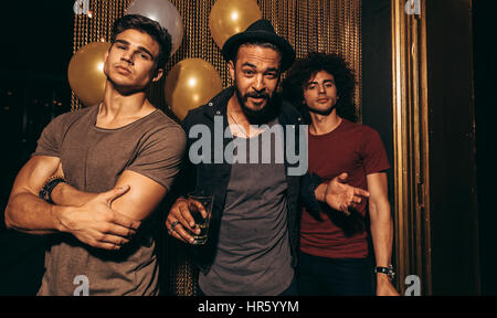 Porträt von drei junge Männer stehen in einem Nachtclub. Stilvolle Gruppe von Männern im Pub. Stockfoto