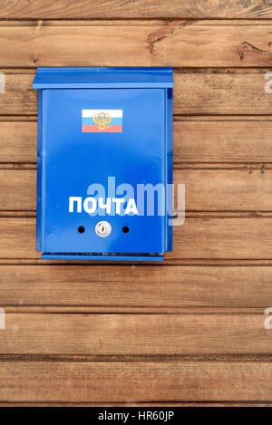 Russische Post Box mit Flagge der Russischen Föderation und aus blau lackiertem Metall, gesetzt auf einem äußeren Holzzaun. Stockfoto