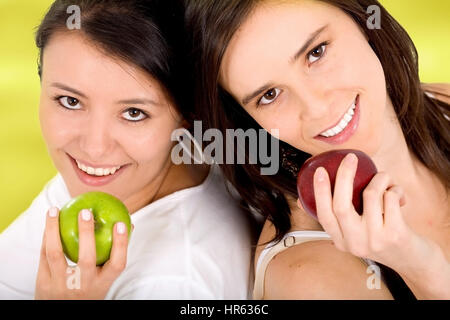 gesundes Mädchen auf eine Ernährung mit Früchten Äpfel über einen hellgrünen Hintergrund auf ihren Händen zu halten Stockfoto