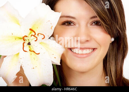 gesundes Mädchen, Lächeln, Porträt, die eine Blume neben ihr Gesicht - auf einem weißen Hintergrund isoliert Stockfoto
