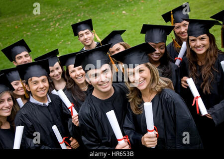 Gruppe von Studenten der Graduierung im Park suchen glücklich Stockfoto