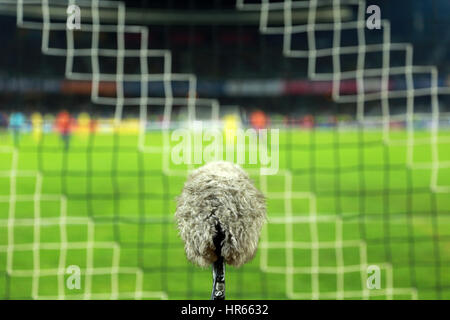 Big and furry sport microphone on a soccer field behind the goal net Stockfoto