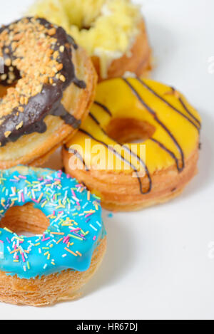 Verschiedene Arten von Donuts auf weißen Tisch Stockfoto