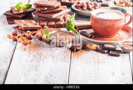 Auswahl an verschiedenen Schokoladen und Kaffee auf einem weißen Hintergrund aus Holz. Stockfoto