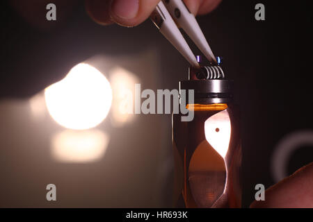 Testen Sie brennen die neue dual Kanthal Mikro Spulen auf der Zerstäuber Deck Basis der elektronischen Zigarette für dampfen, Szene hautnah. Stockfoto