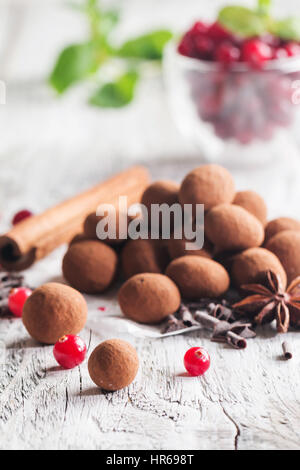 Hausgemachte gesunde vegane Schokolade Trüffel mit Cranberry auf Papier auf weißem Holz Hintergrund Stockfoto