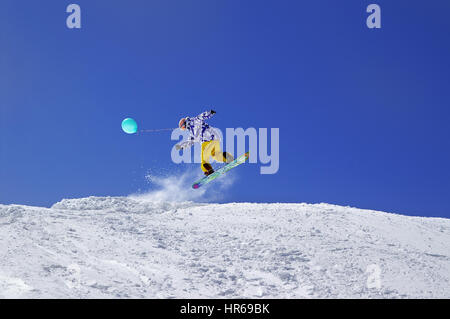 Snowboarder springen mit Spielzeug Ballon im Funpark im Skigebiet auf Sonne Wintertag. Kaukasus-Gebirge, Region Dombay. Stockfoto