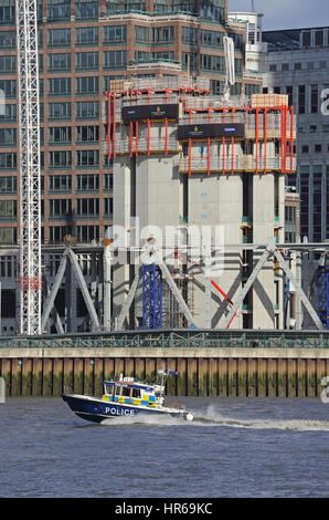 Eine Polizei starten Geschwindigkeiten entlang der Themse in London, Vereinigtes Königreich, vorbei an einer Baustelle in ein Canary Wharf. Stockfoto