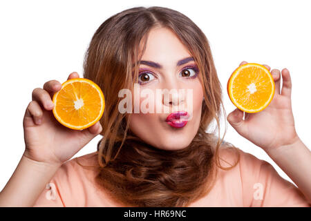 Junge schöne Mädchen mit Orangenscheibe und Make-up und Frisur Blick in die Kamera. Studioaufnahme, isoliert auf weißem Hintergrund. Stockfoto